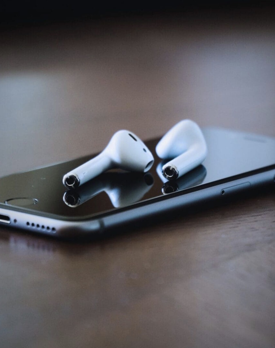 Wireless earbuds resting on a smartphone